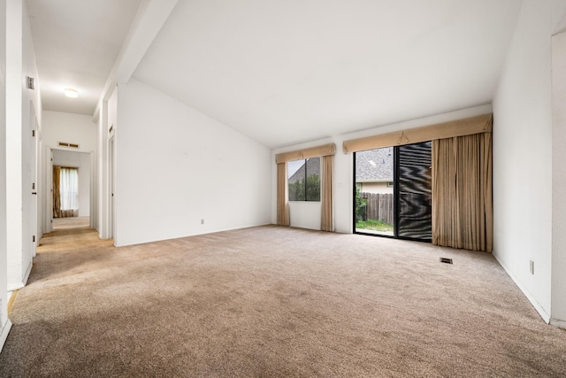 carpeted spare room featuring vaulted ceiling