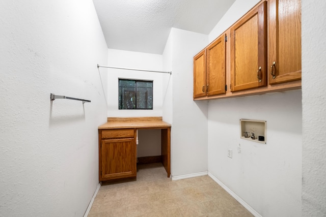 clothes washing area with cabinets, a textured ceiling, and washer hookup