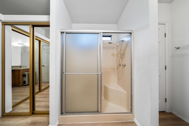 bathroom with an enclosed shower and wood-type flooring