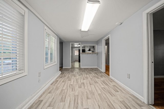 hallway featuring a healthy amount of sunlight and light hardwood / wood-style flooring