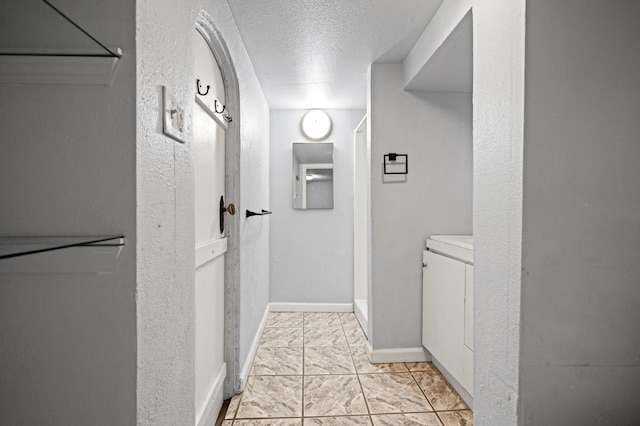 hallway featuring a textured ceiling and light tile patterned flooring