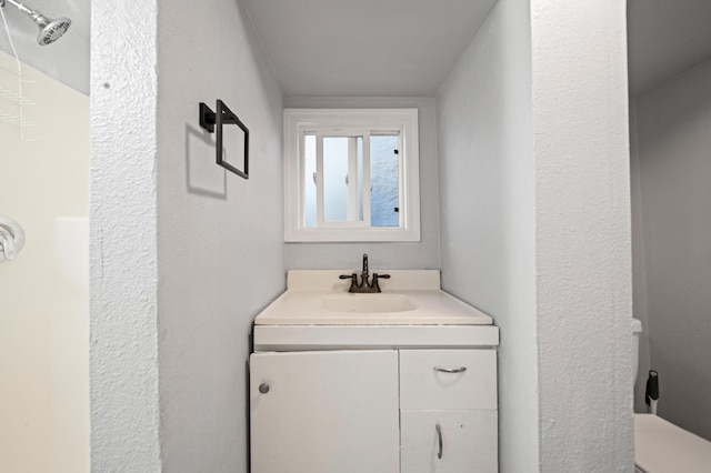 bathroom featuring a shower and vanity