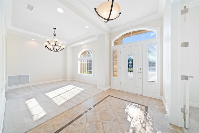 carpeted entryway featuring ornamental molding and a chandelier