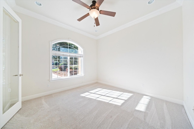 carpeted spare room with ceiling fan and crown molding