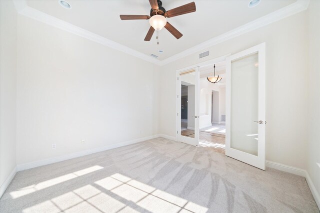 carpeted spare room featuring ornamental molding, french doors, and ceiling fan