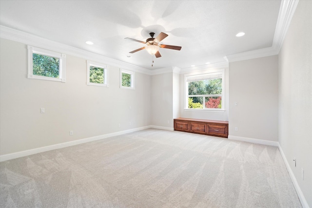 spare room featuring light colored carpet, a healthy amount of sunlight, and crown molding