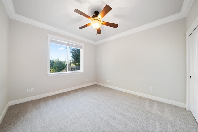 carpeted empty room featuring ceiling fan and crown molding