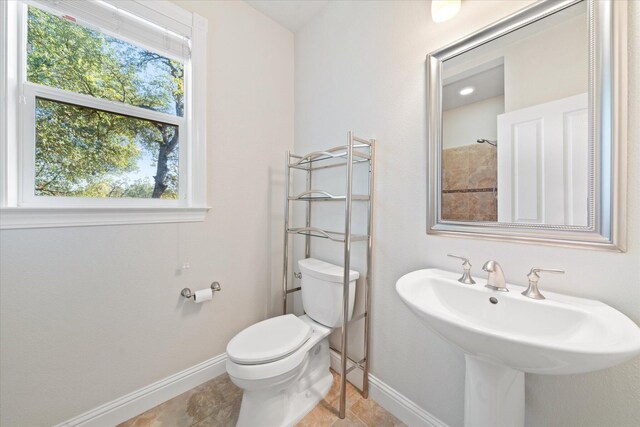 bathroom featuring a shower, toilet, and sink