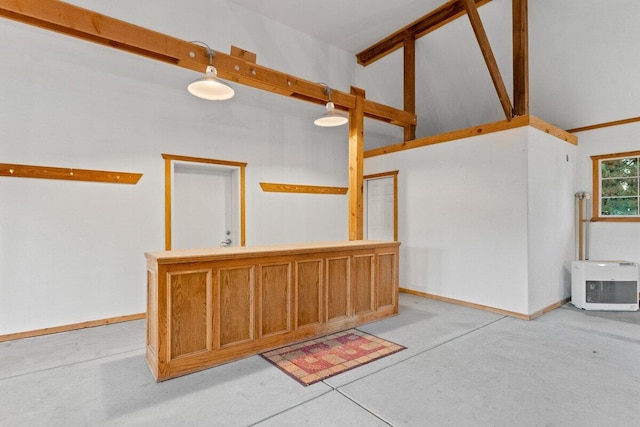 empty room with vaulted ceiling with beams