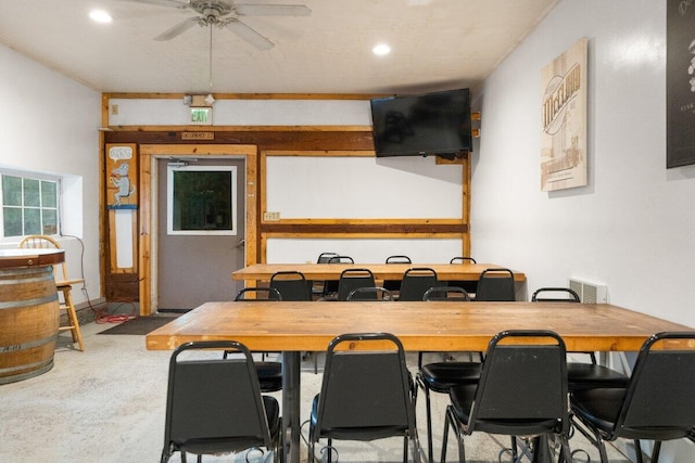 carpeted dining space with ceiling fan