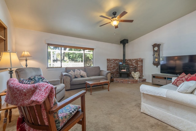 carpeted living room featuring ceiling fan, a wood stove, and lofted ceiling