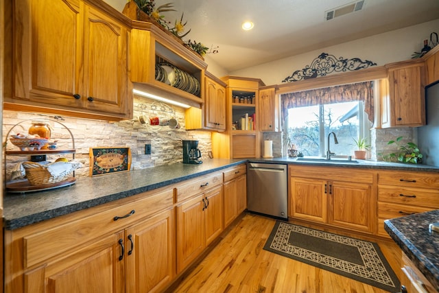 kitchen featuring tasteful backsplash, dishwasher, light hardwood / wood-style floors, and sink