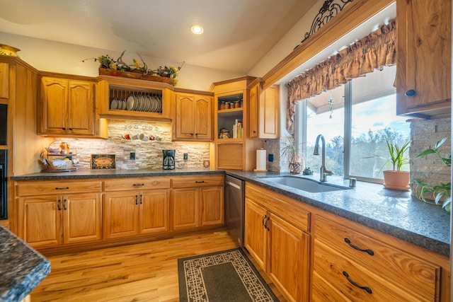 kitchen with light hardwood / wood-style flooring, stainless steel dishwasher, tasteful backsplash, and sink