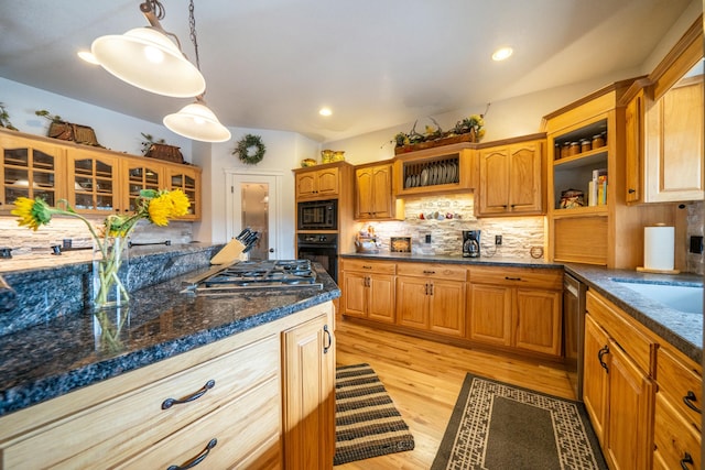 kitchen with decorative backsplash, light wood-type flooring, dark stone counters, black appliances, and decorative light fixtures