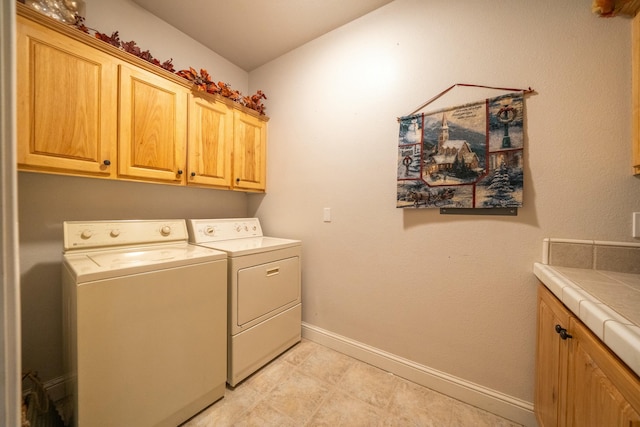 washroom featuring cabinets and washer and clothes dryer