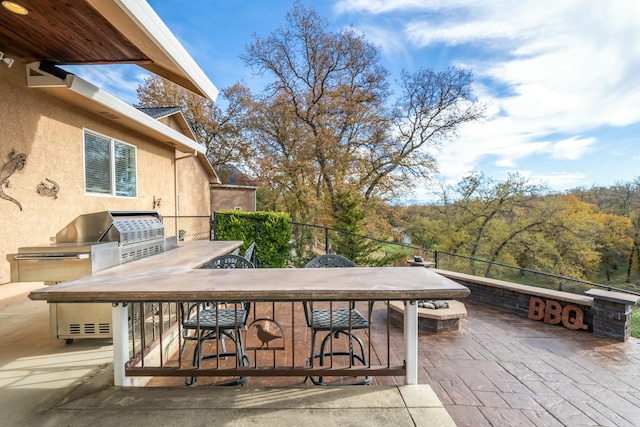 view of patio / terrace with a bar, an outdoor kitchen, and grilling area