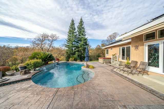 view of pool with a patio and a hot tub