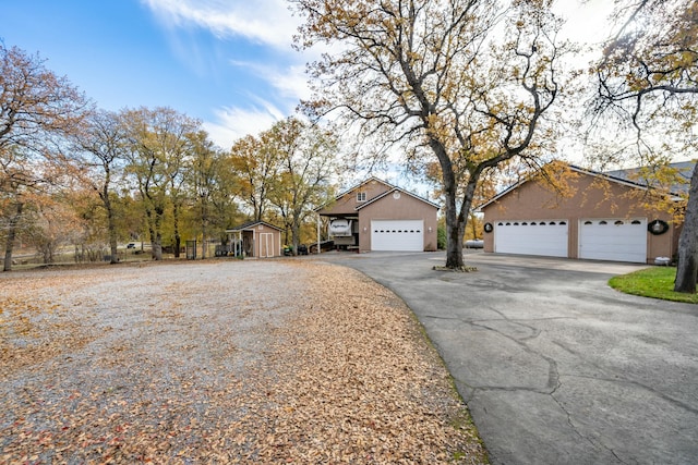 view of front of house with a garage and a storage unit