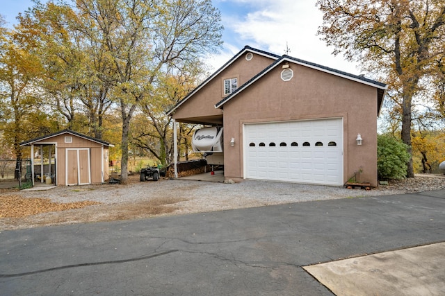 view of front of house with a garage and a shed