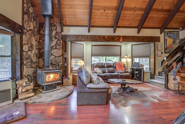 living room featuring a wood stove, beam ceiling, wood-type flooring, and wood ceiling