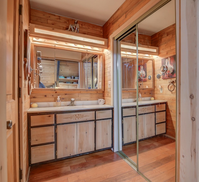 bathroom featuring hardwood / wood-style floors, vanity, and wooden walls