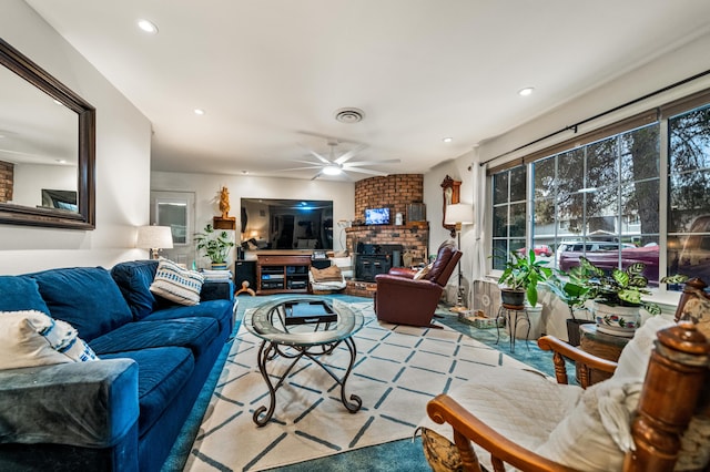 living room with a brick fireplace and ceiling fan