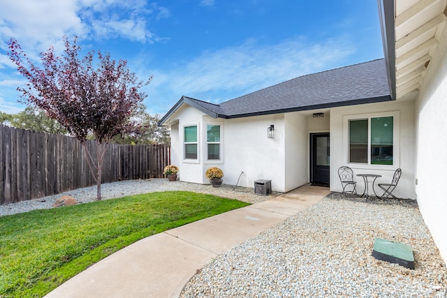 property entrance with a patio area and a lawn