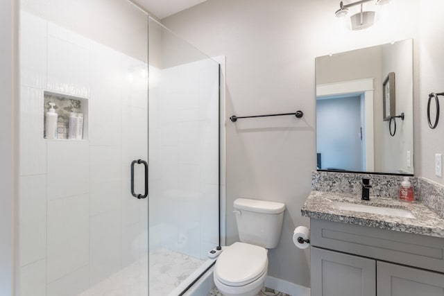 bathroom featuring toilet, an enclosed shower, and vanity