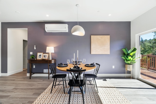 dining area featuring a wall mounted AC and wood-type flooring