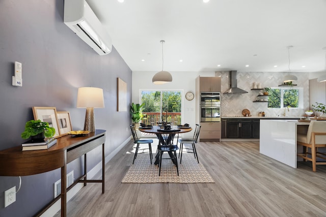 dining room featuring light hardwood / wood-style floors, a wall mounted AC, and sink