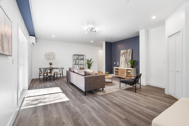 living room with hardwood / wood-style floors and an AC wall unit