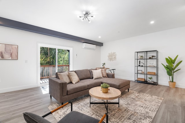 living room with a wall mounted air conditioner, light hardwood / wood-style flooring, and an inviting chandelier