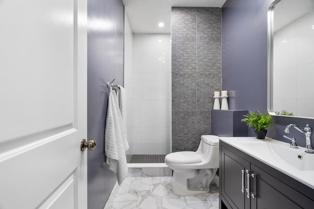 bathroom with toilet, vanity, and a tile shower