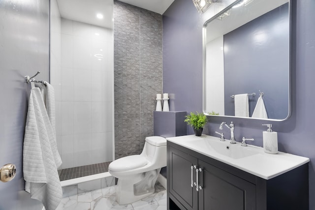 bathroom with toilet, vanity, and tiled shower