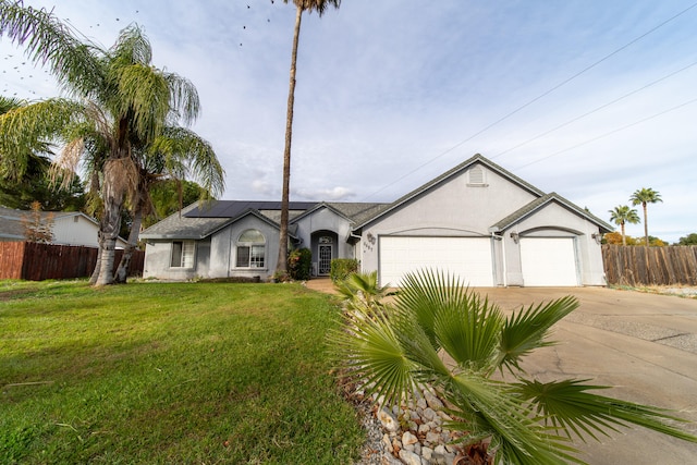 ranch-style house with solar panels, a garage, and a front lawn