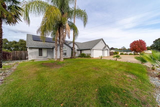 view of front of property featuring solar panels, a garage, and a front lawn