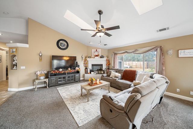 carpeted living room with ceiling fan, a fireplace, and vaulted ceiling