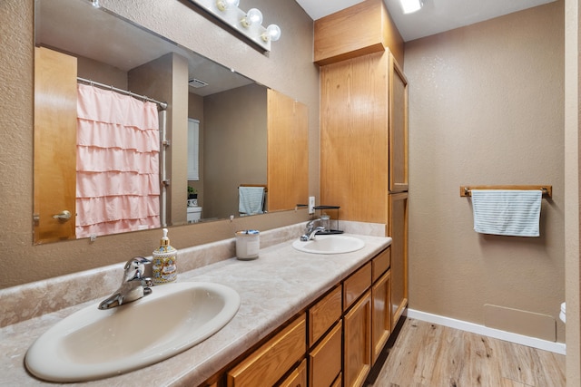 bathroom featuring toilet, hardwood / wood-style flooring, and vanity