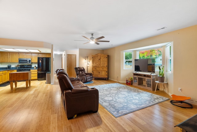 living room with light wood-type flooring and ceiling fan