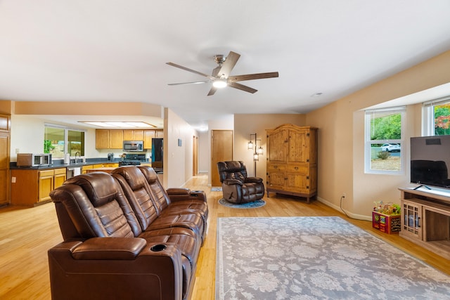 living room with ceiling fan, light hardwood / wood-style flooring, and plenty of natural light