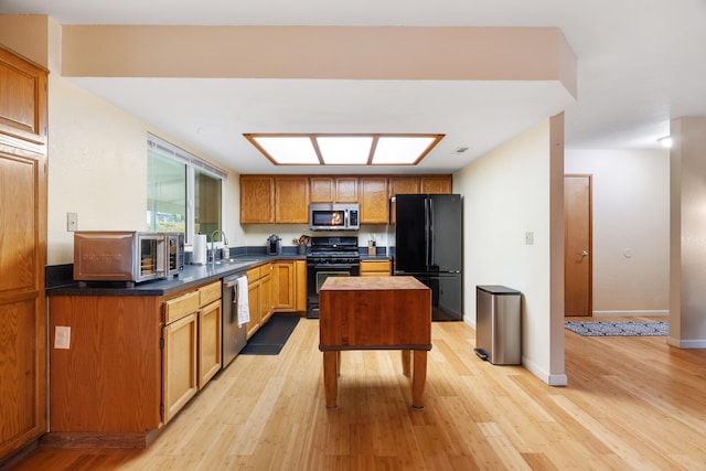 kitchen featuring light hardwood / wood-style flooring, black appliances, and sink