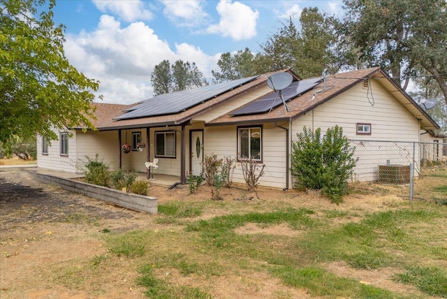 view of front facade with solar panels and cooling unit