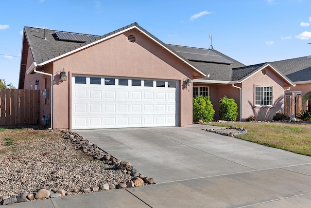 ranch-style house with solar panels and a garage