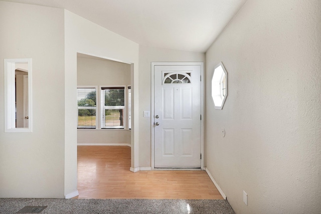 entrance foyer with wood-type flooring and vaulted ceiling