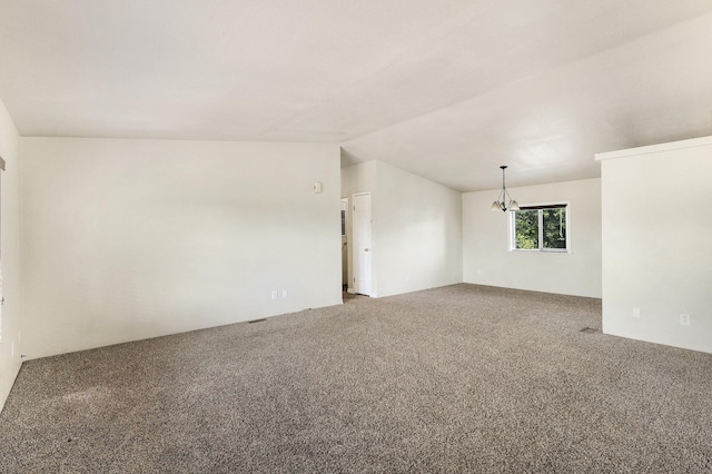 unfurnished room featuring lofted ceiling, a notable chandelier, and carpet floors