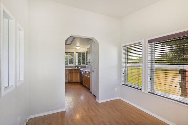 hall with light hardwood / wood-style flooring and sink