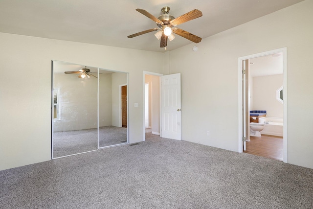 unfurnished bedroom with carpet flooring, a closet, ceiling fan, lofted ceiling, and connected bathroom