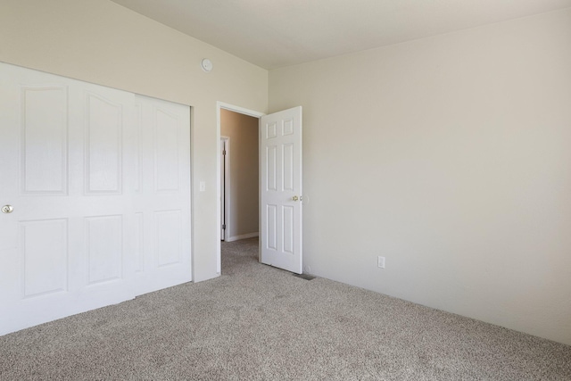 unfurnished bedroom featuring carpet floors and a closet