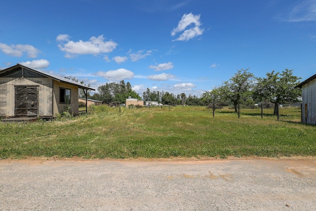 view of yard with a storage unit and a rural view