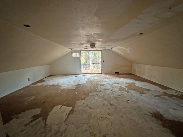 bonus room with ceiling fan, a textured ceiling, and vaulted ceiling